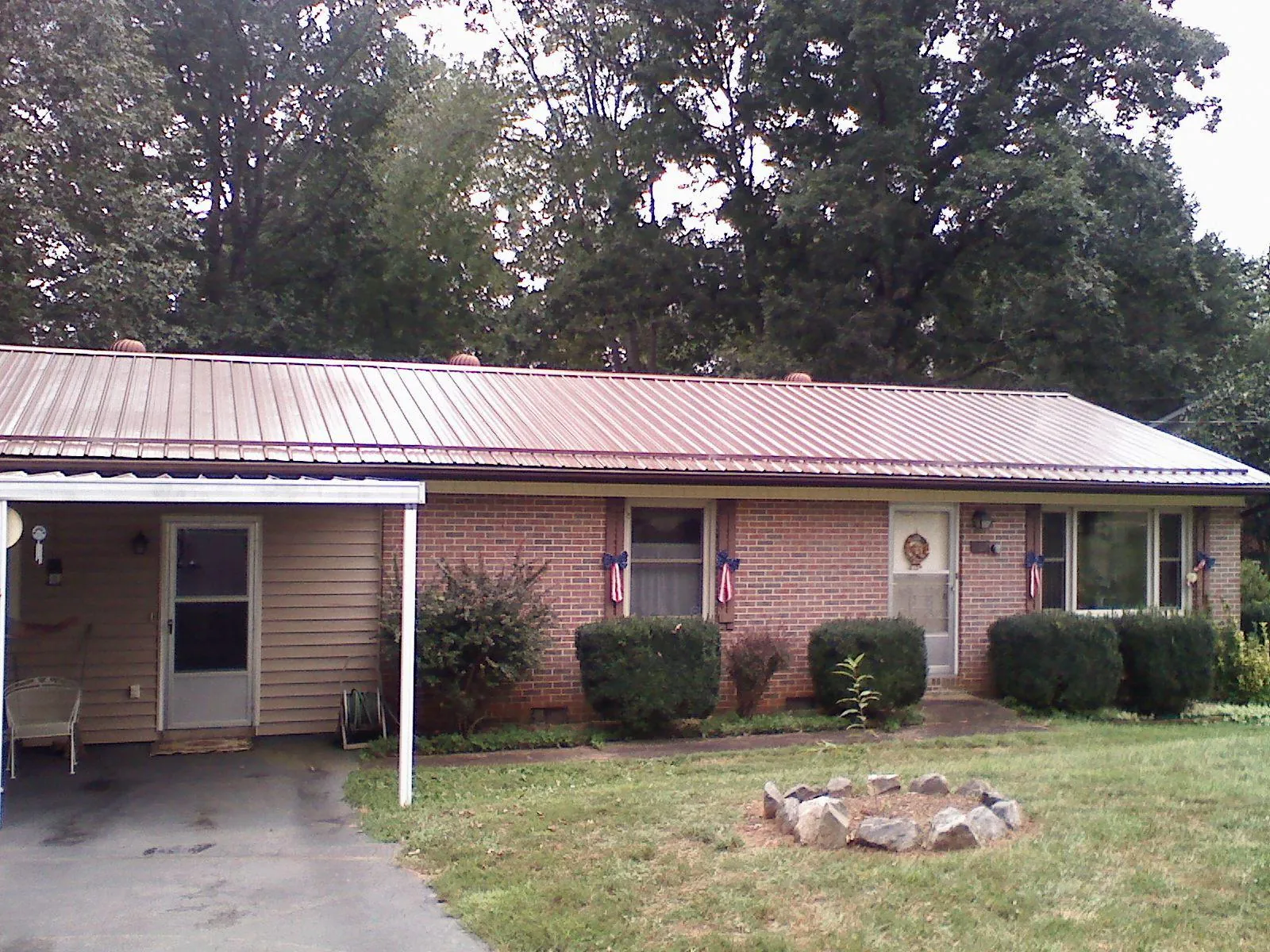 Bronze metal roof and carport on a brick ranch home — Roof Repair work by our crew in Mc Rae Helena